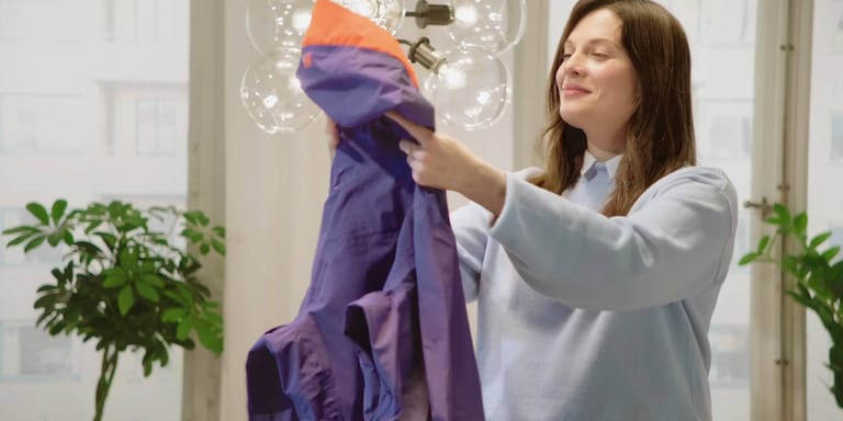 Жена държи яке за ски