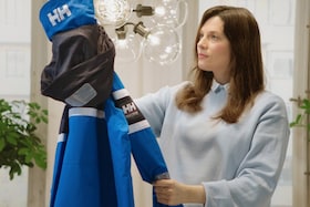 Жена държи свежо изпрано яке за ски Helly Hansen