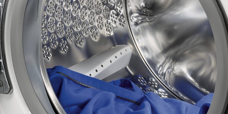 Диаграмата показва разстоянието, което трябва да оставите между дрехите и тавана на барабана.