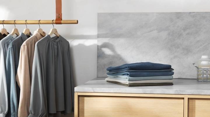 Сгънати дрехи заедно с висящи дрехи