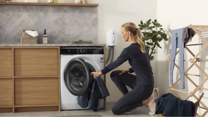 Жена зарежда пералня Electrolux 